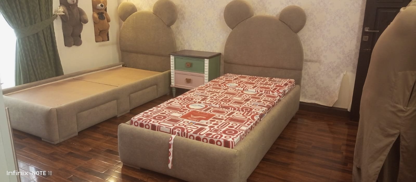 Twin bed frames set up in a child's room, ready for the mattress